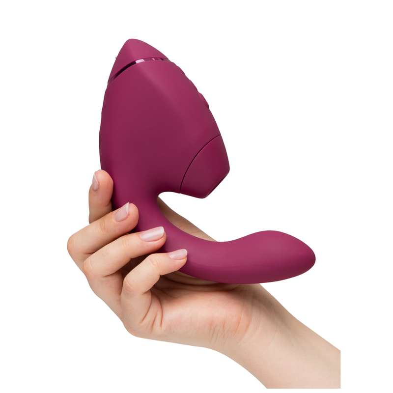 Womanizer Duo Next rosa scuro tenuto in mano, vista laterale
